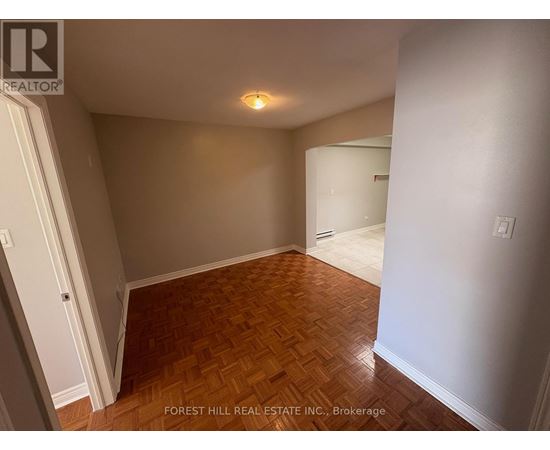 A room with wooden flooring and white walls.