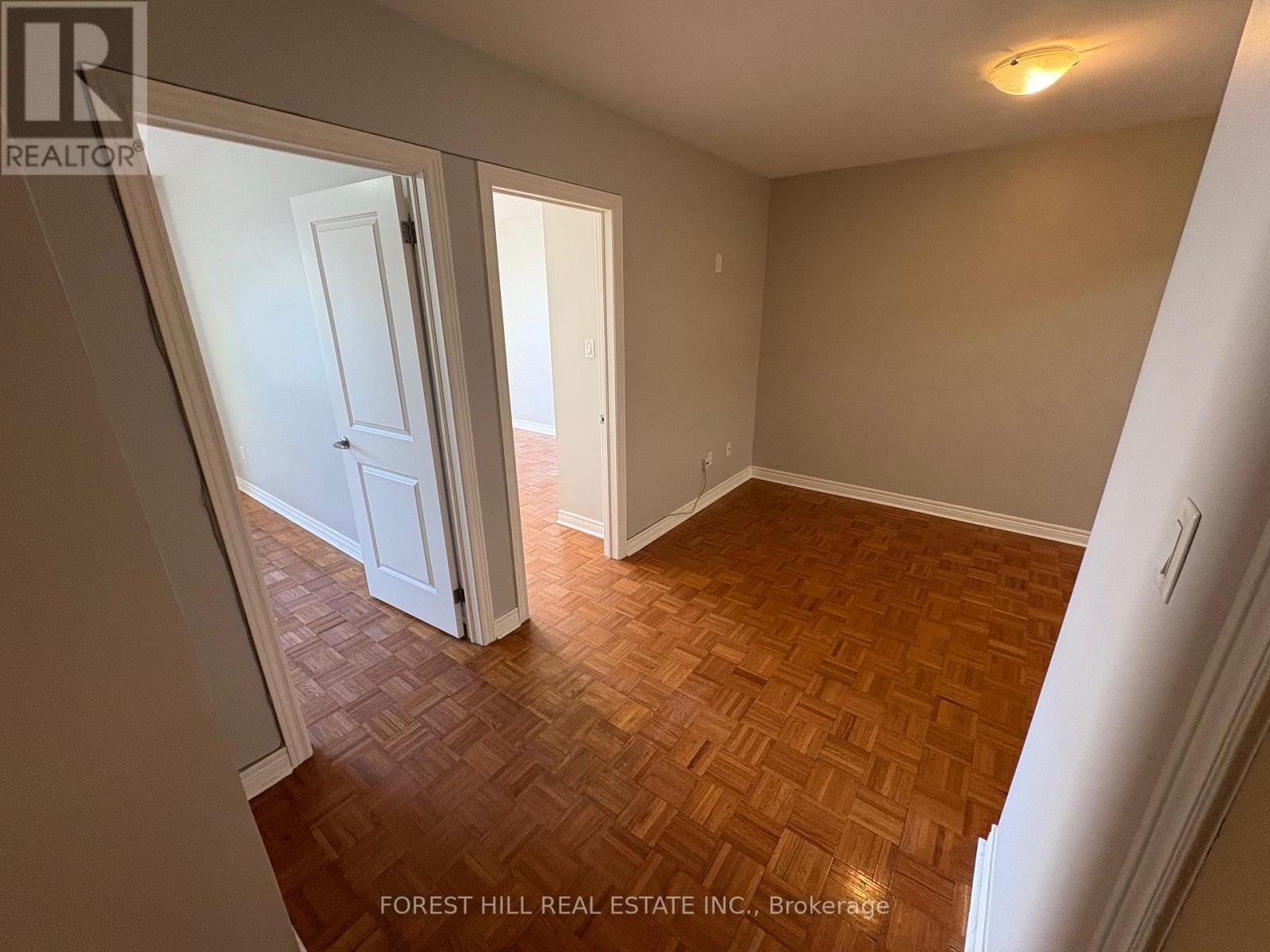 A room with wooden flooring and white walls.