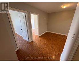 A room with wooden flooring and white walls.