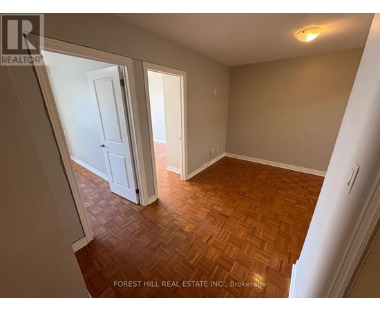A room with wooden flooring and white walls.