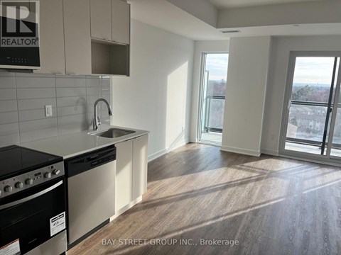 A kitchen with a black stove top oven and white cabinets.