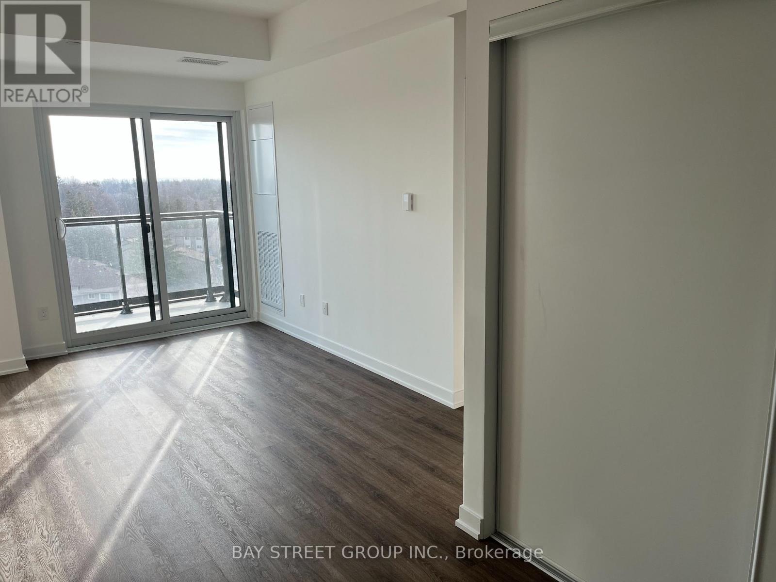 A room with a sliding glass door leading to a balcony.