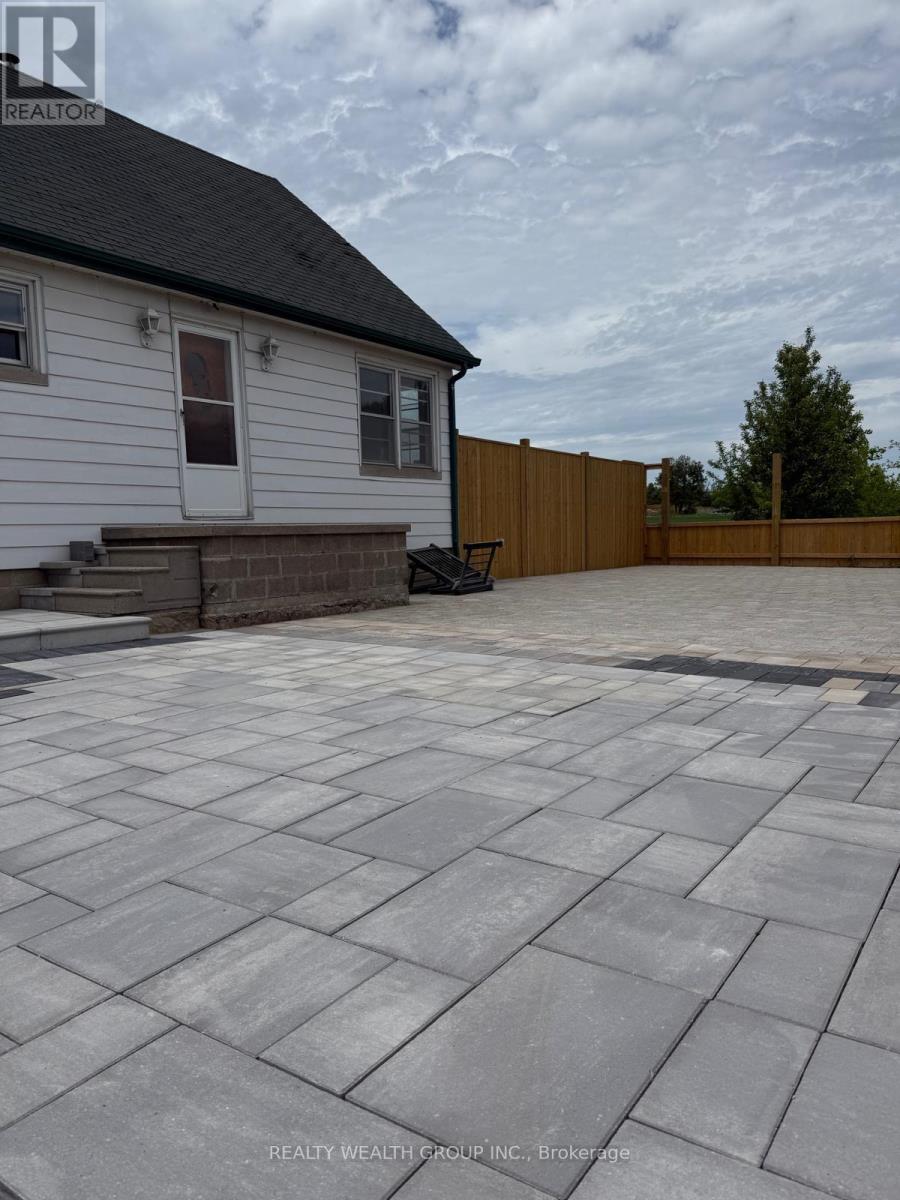 A house with a white exterior and a grey patio.