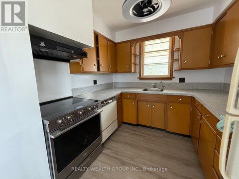 A kitchen with wooden cabinets and a stainless steel oven.