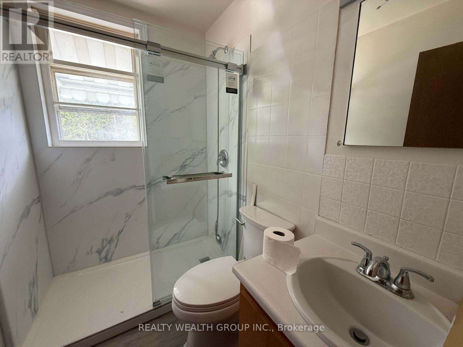 A white toilet sits next to a sink in a bathroom.
