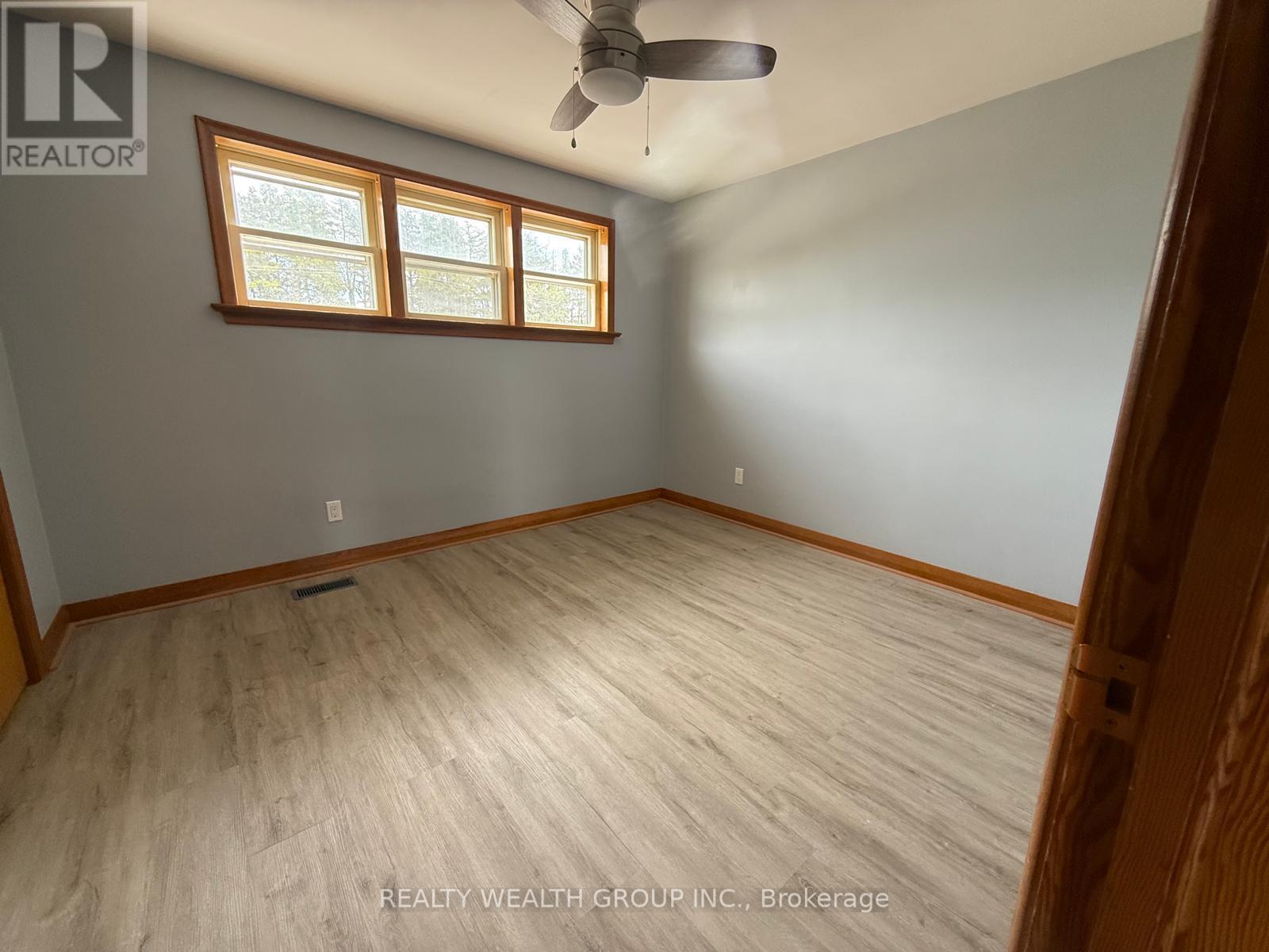 A room with a ceiling fan and a window.