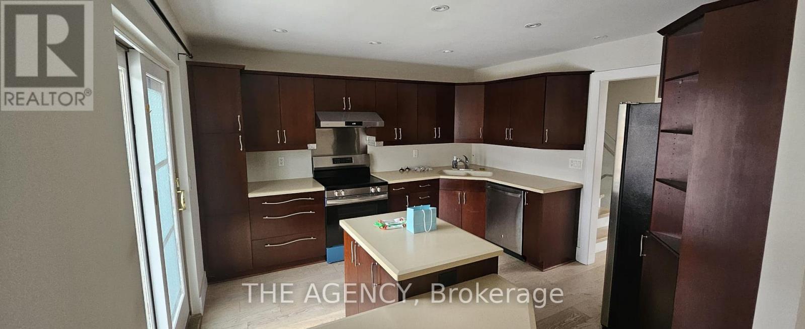 A kitchen with brown cabinets and a white counter top.