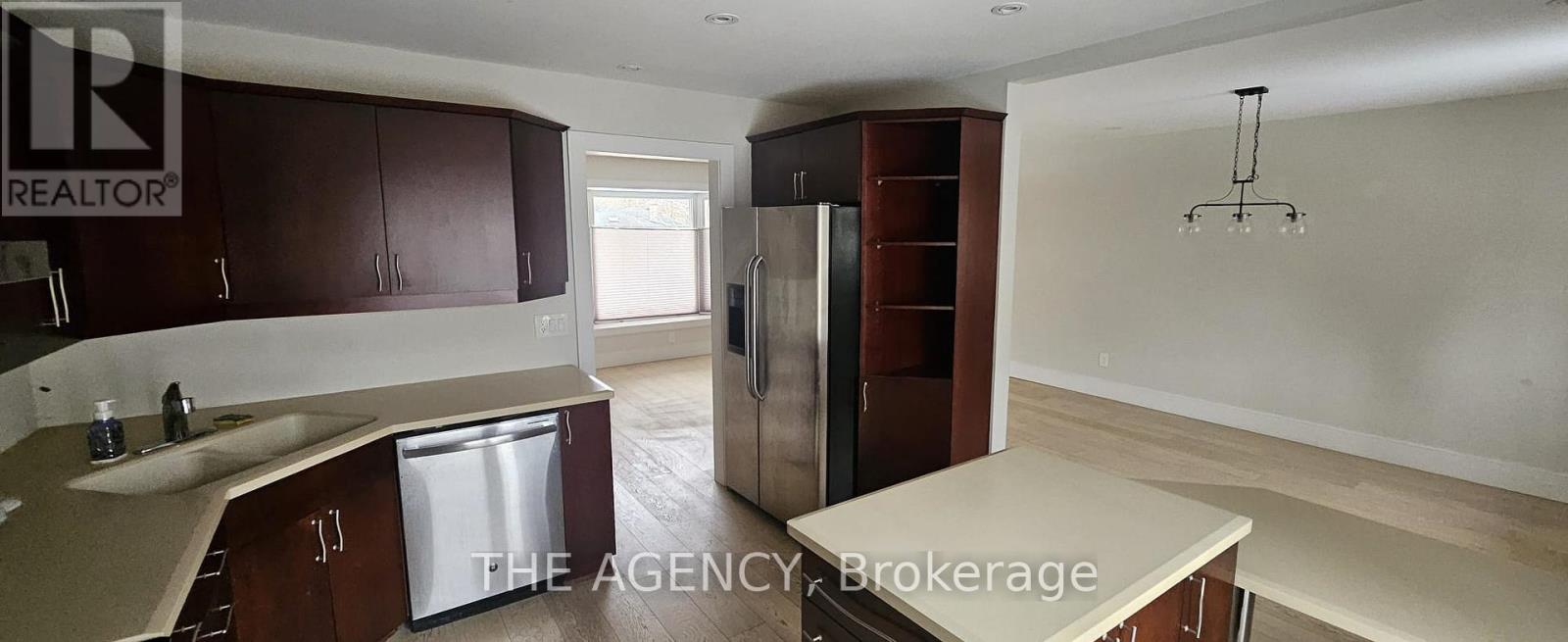 A kitchen with brown cabinets and a refrigerator.