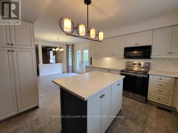 A kitchen with white cabinets and a large island.