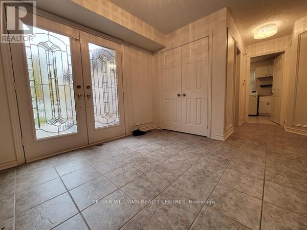 A room with tiled flooring and a large window with a view of trees.