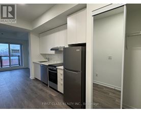 A kitchen with a refrigerator, sink, and stove.