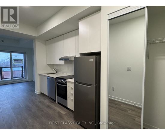 A kitchen with a refrigerator, sink, and stove.