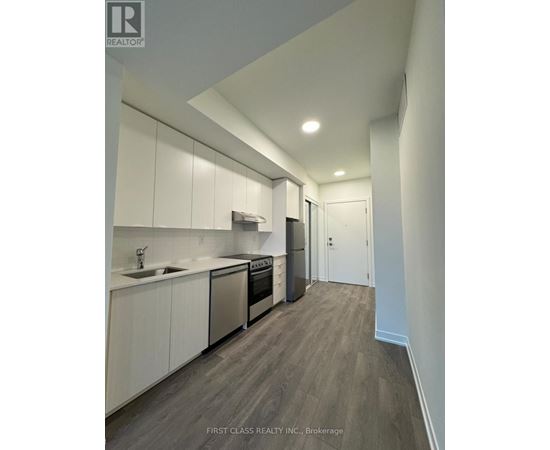 A modern kitchen with white cabinets and stainless steel appliances.