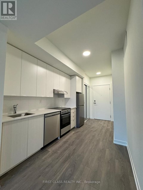 A modern kitchen with white cabinets and stainless steel appliances.