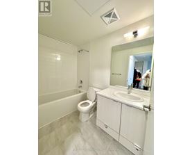 A white bathroom with a toilet, sink, and mirror.