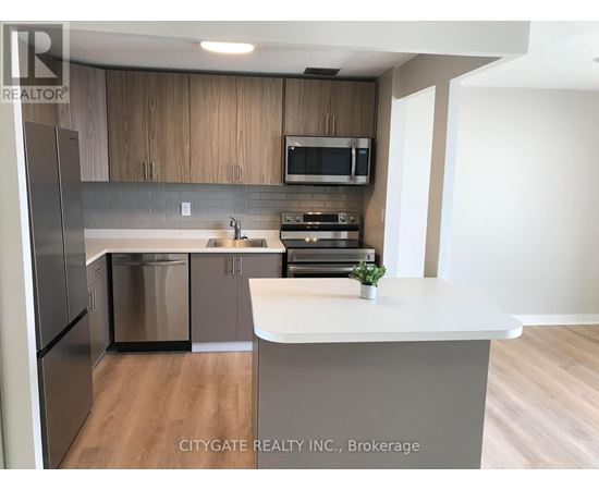 A kitchen with a white counter top and wooden cabinets.