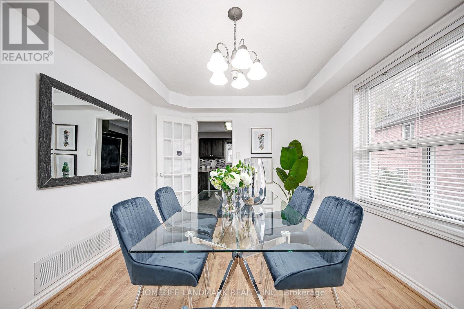 A dining room with a glass table and blue chairs.