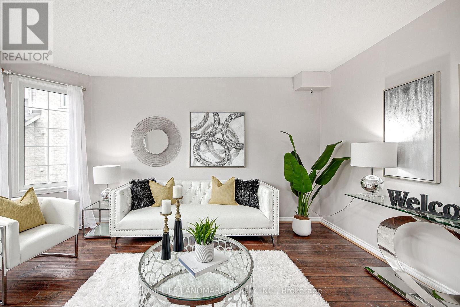 A living room with a white sofa and a glass coffee table.