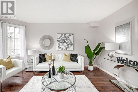 A living room with a white sofa and a glass coffee table.