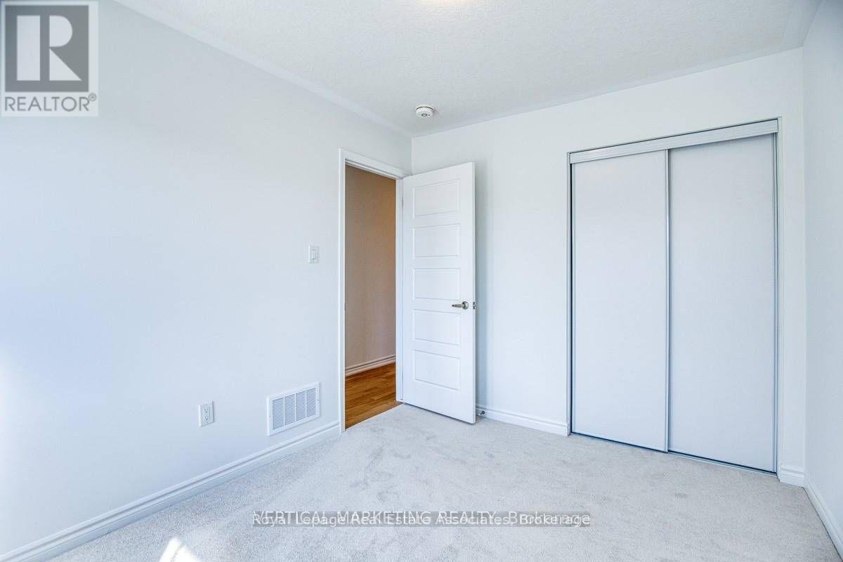 A white bedroom with a sliding door and a white wall.