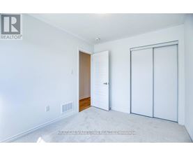 A white bedroom with a sliding door and a white wall.