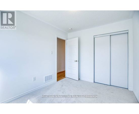 A white bedroom with a sliding door and a white wall.