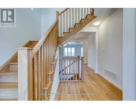 A wooden staircase with a white wall on the side.