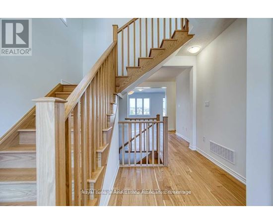 A wooden staircase with a white wall on the side.