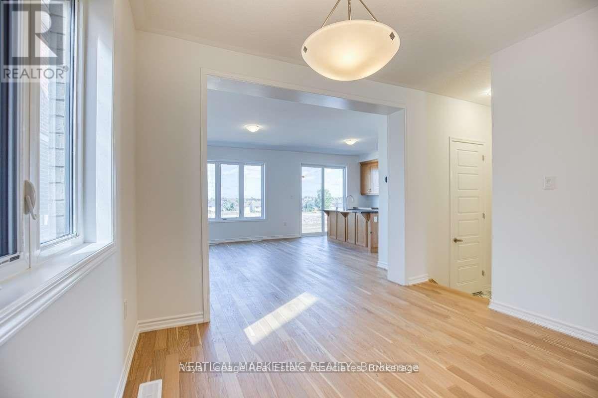 A well-lit, spacious room with wooden floors and white walls.