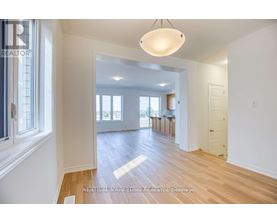 A well-lit, spacious room with wooden floors and white walls.