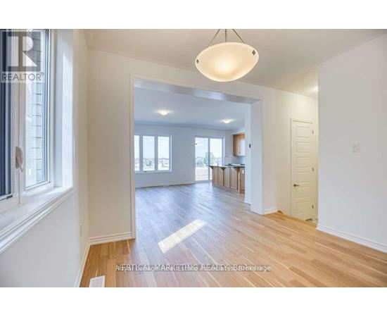A well-lit, spacious room with wooden floors and white walls.