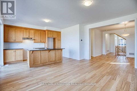 A well-lit kitchen with wooden cabinets and a large island.