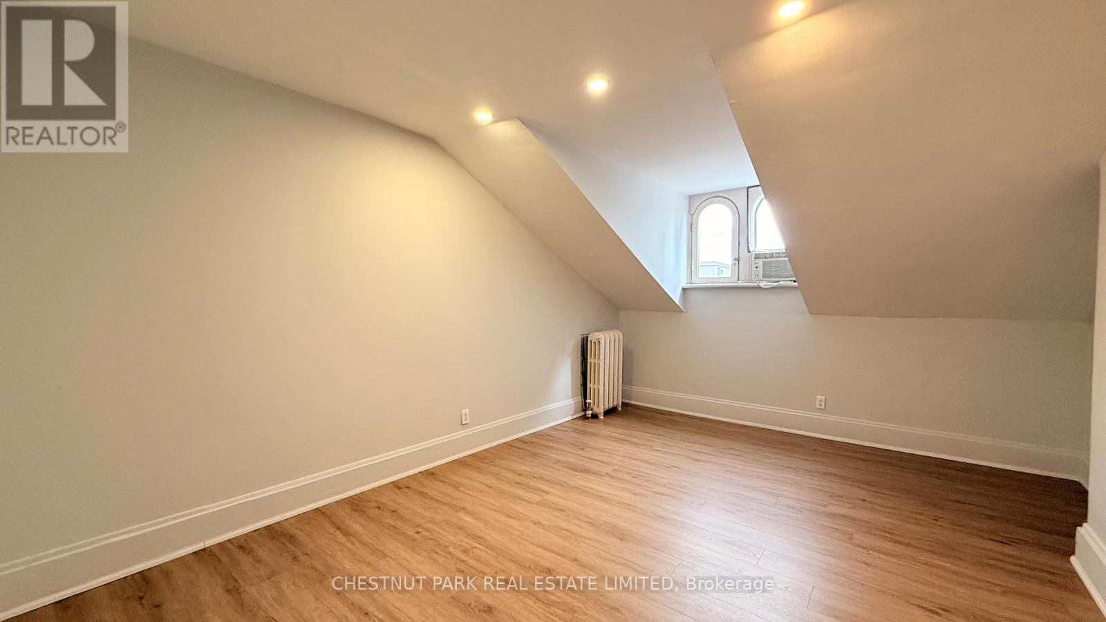 A room with wooden flooring and a window.