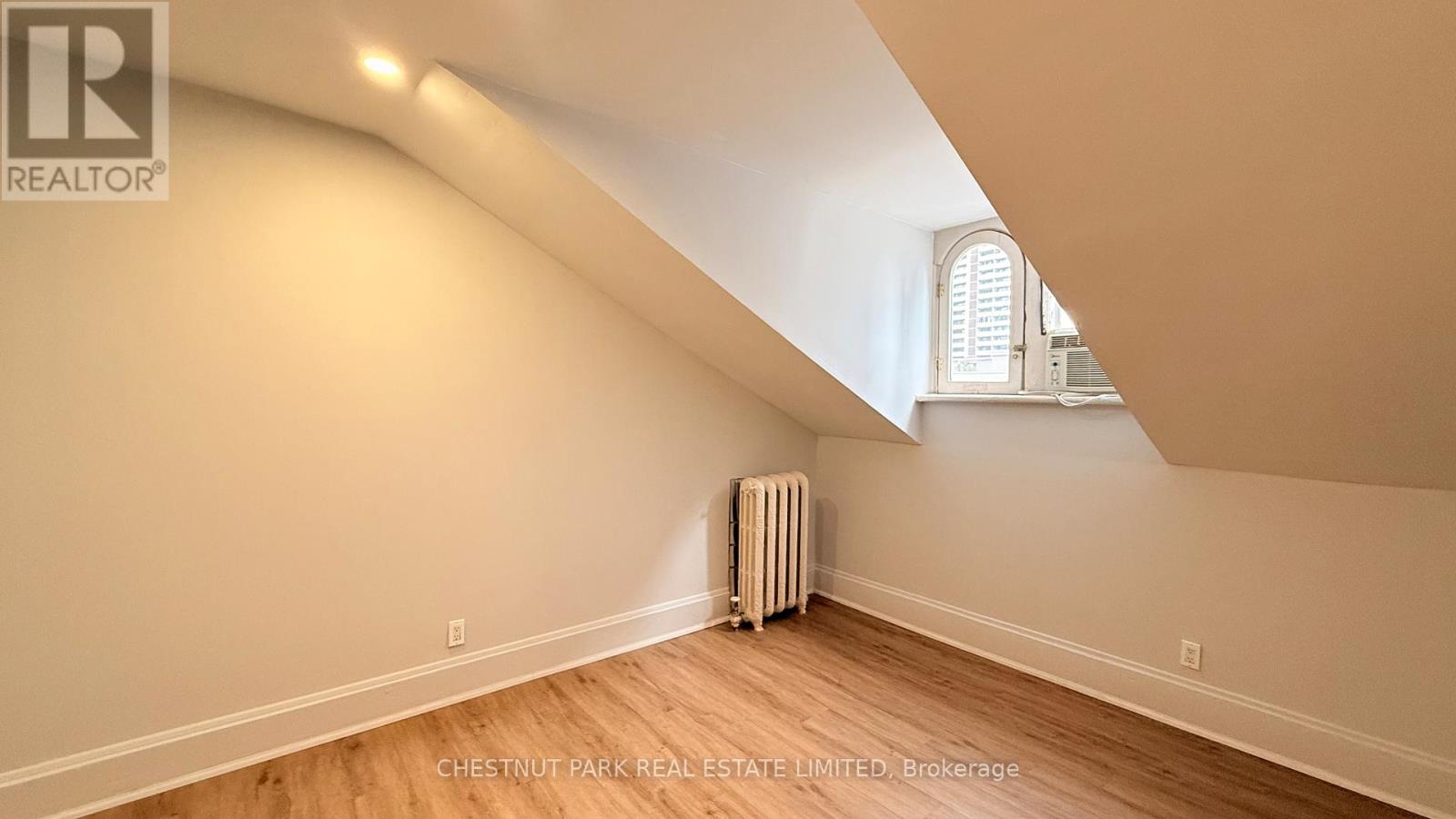A room with a window and a radiator on the floor.