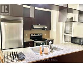 A kitchen with a stainless steel refrigerator and a granite counter top.