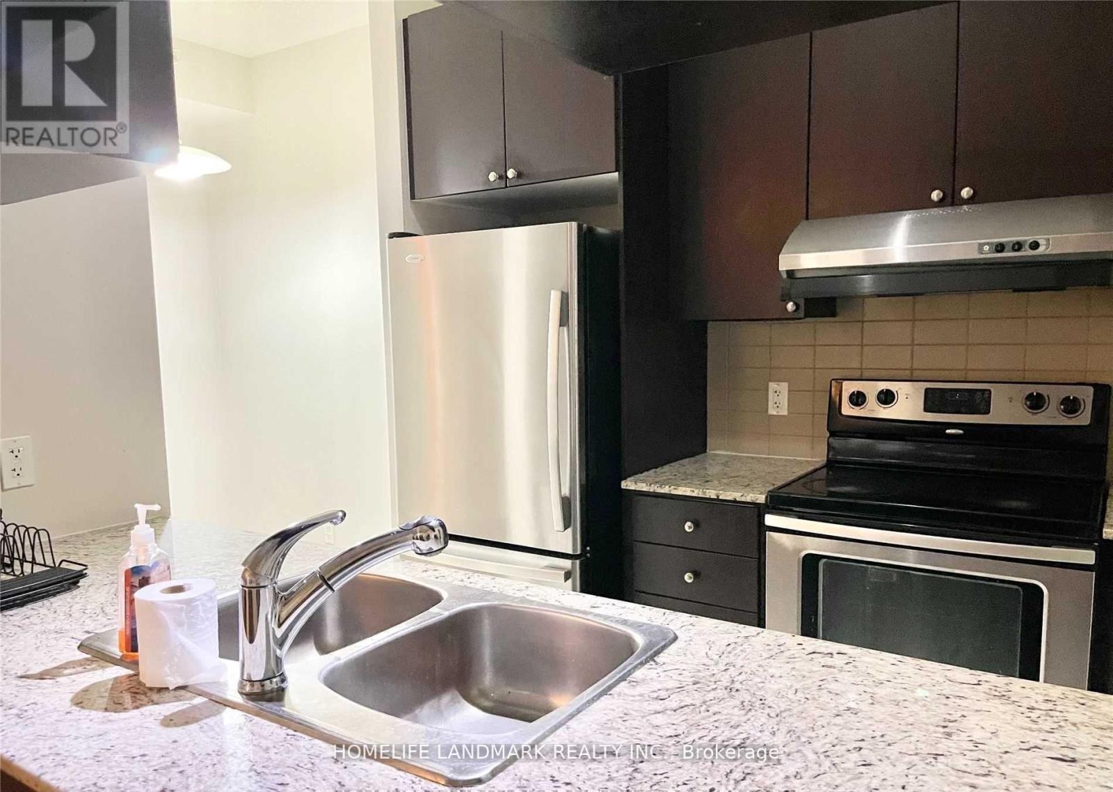 A kitchen with a sink and a refrigerator.