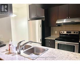 A kitchen with a sink and a refrigerator.