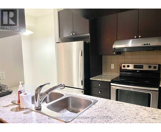 A kitchen with a sink and a refrigerator.