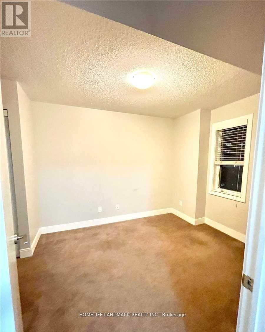 A room with white walls and a brown carpet.