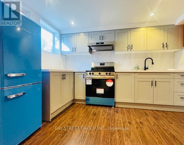 A kitchen with a blue fridge and wooden floors.