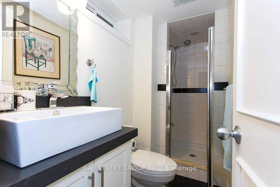 A bathroom with a toilet, sink, and shower.