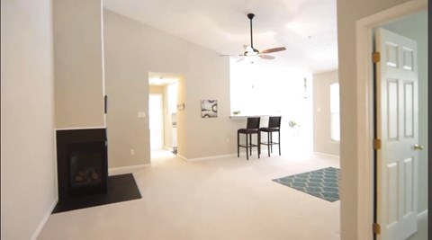 A living room with a fireplace and a ceiling fan.
