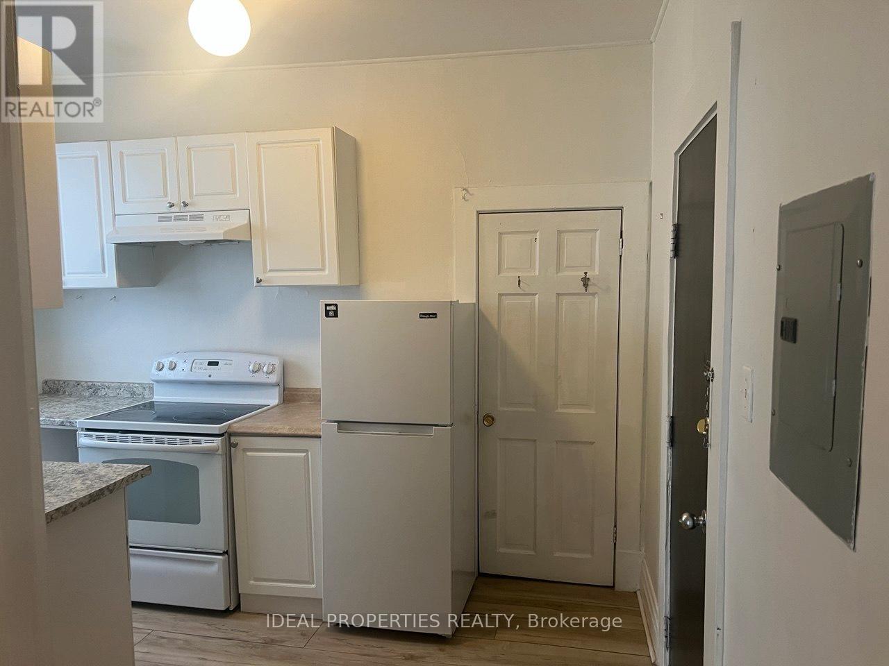 A kitchen with white cabinets and appliances.