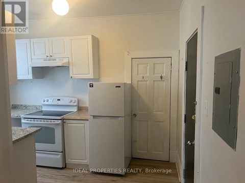 A kitchen with white cabinets and appliances.