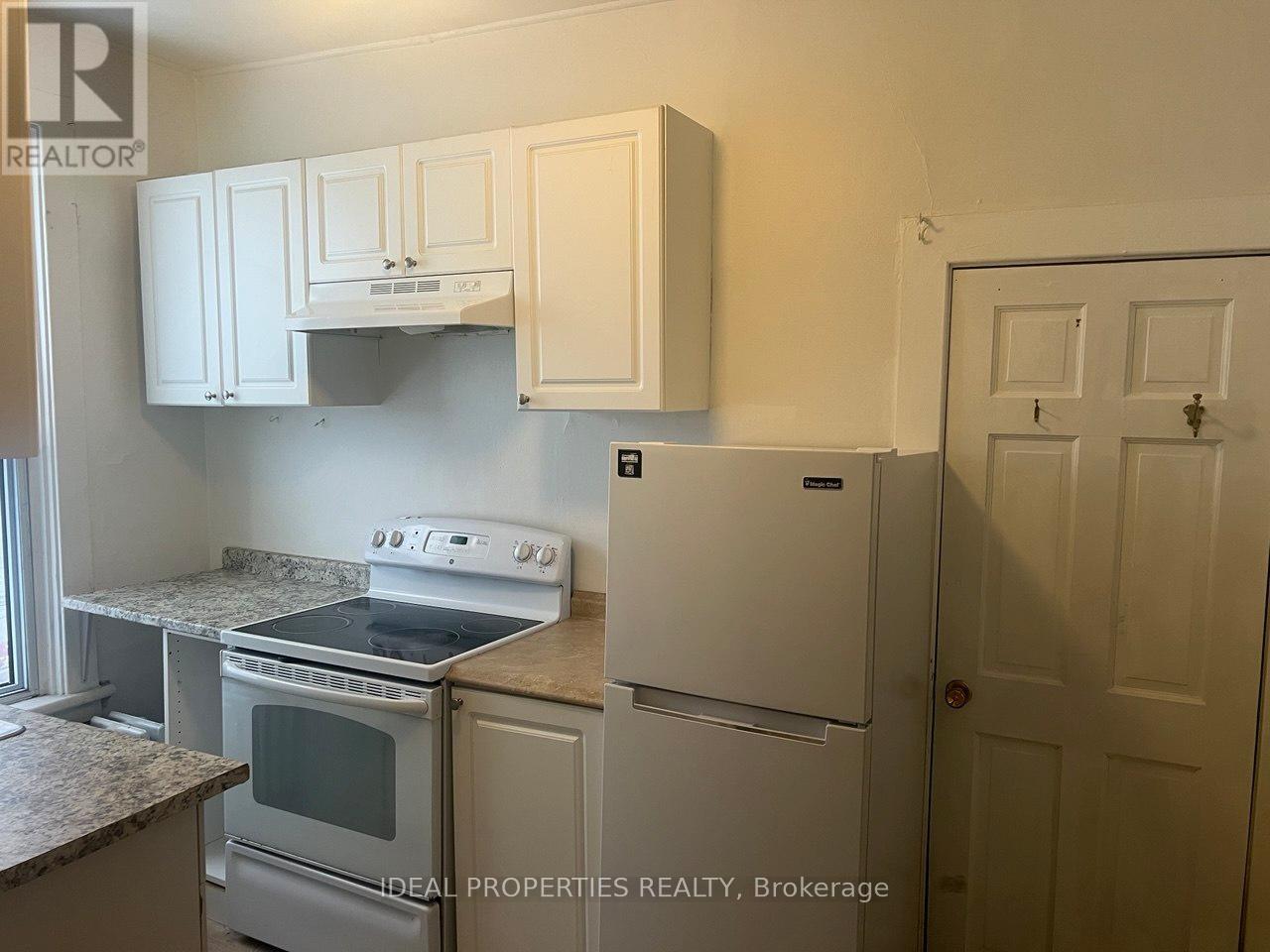 A kitchen with white cabinets and appliances.