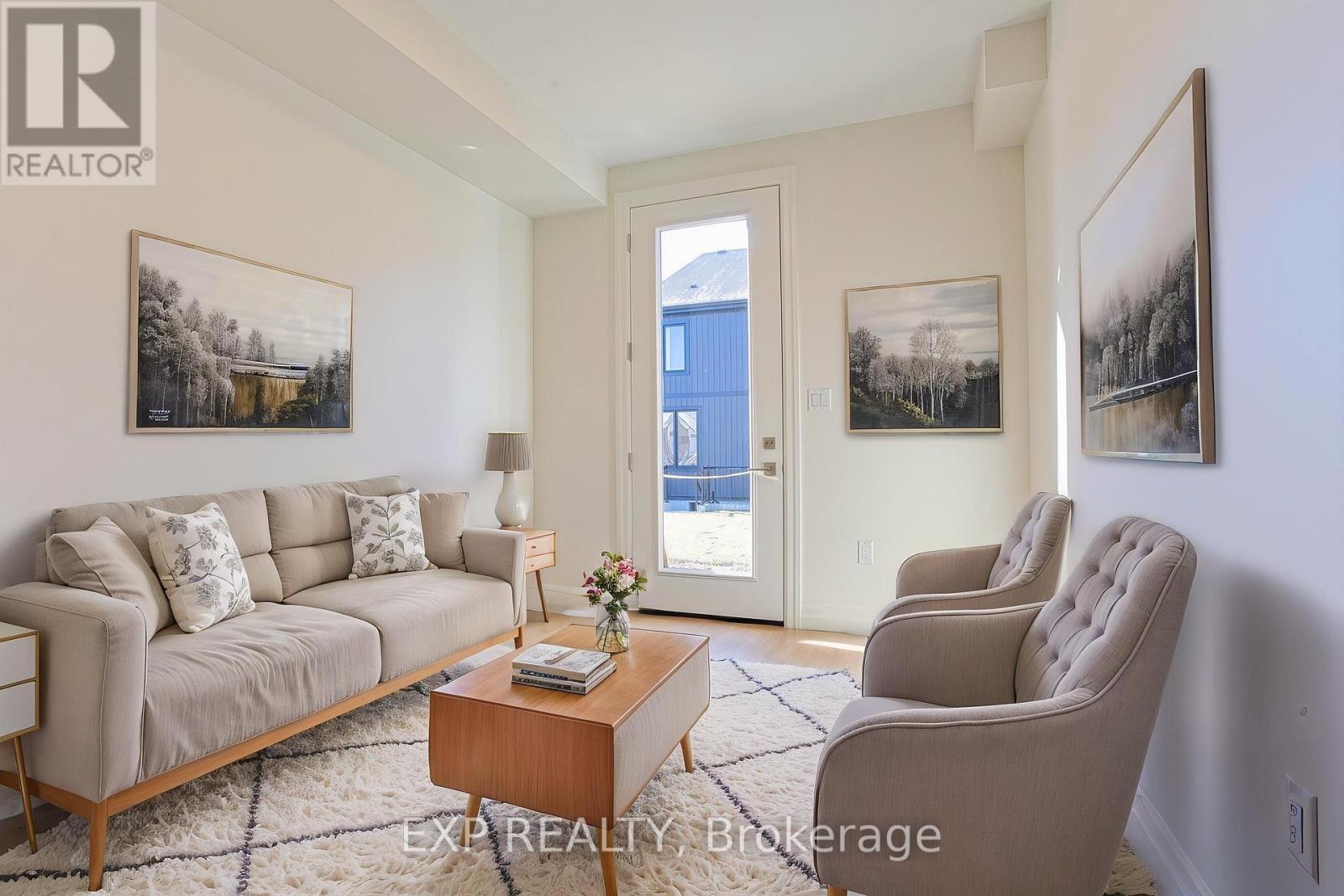 A living room with a couch, chair, and pictures on the wall.