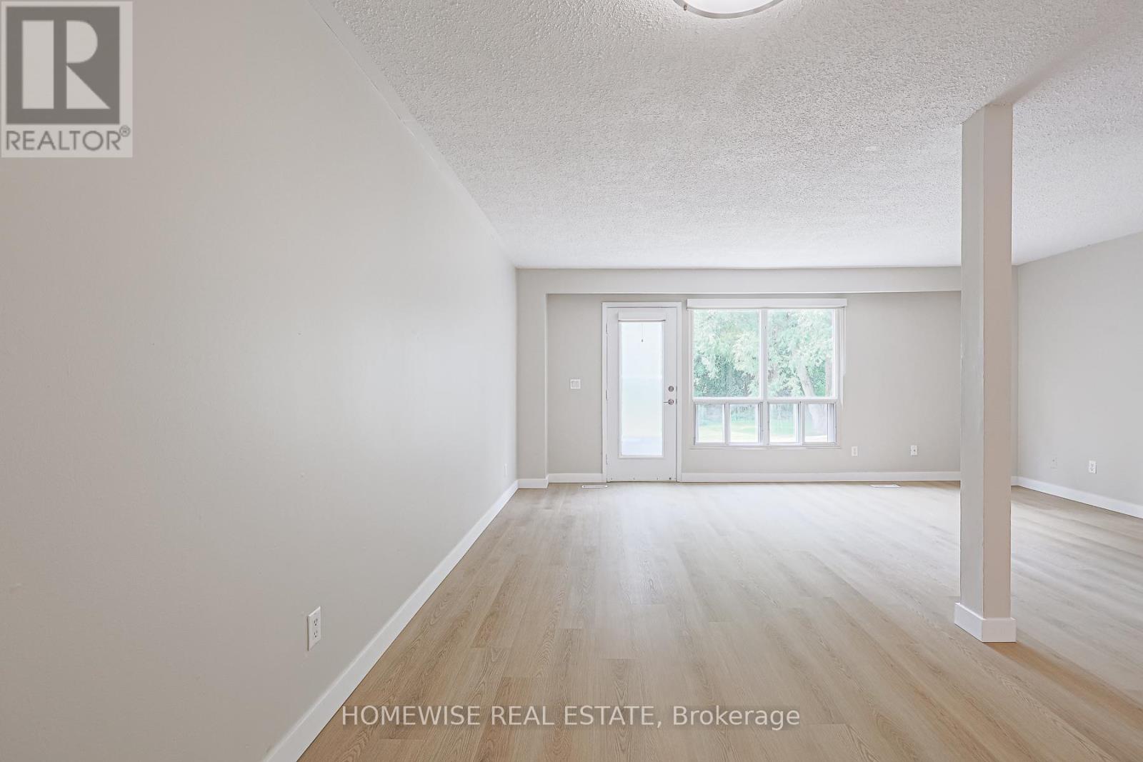 A spacious room with a sliding glass door leading to a balcony.