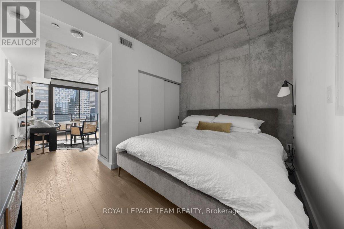 A bedroom with a large bed and a desk with a chair.