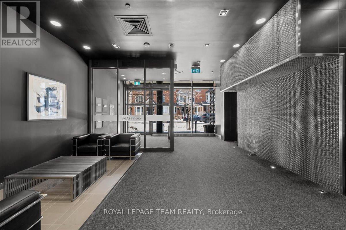 A black and white image of a modern office space with a glass wall and a grey carpet.
