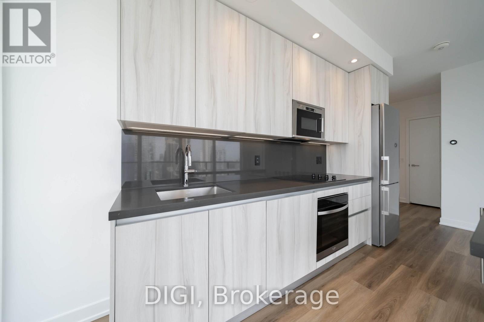 A modern kitchen with white cabinets and a grey countertop.
